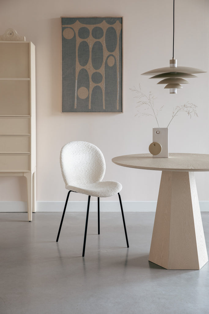 Round Table Pilar Brown Rice with white chair at a room setting.