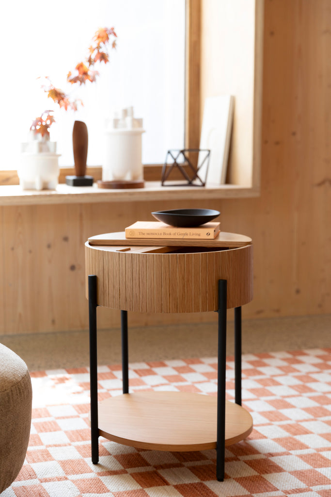 Side table in natural colour with a book and small plate.