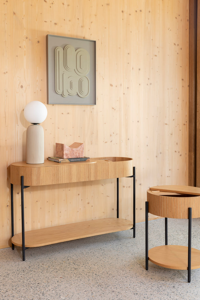 Side table in natural colour with black legs in room setting with matching cabinet.