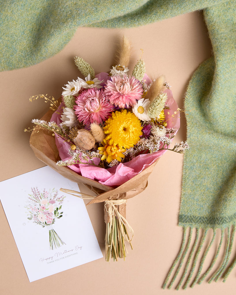 This thoughtful bundle from Foxford is perfect for showing appreciation for Mother's Day. Featuring a beautifully hand-tied wildflower posy from Willow and Wild Farm, the flowers are grown and dried in the hills of Foxford. The everlasting bouquet includes delicate strawflowers, statice, daisies, and wild grasses, ensuring it lasts many seasons. Paired with a soft, green lambswool scarf crafted in our mill in County Mayo, this set exudes warmth and natural charm. The bundle comes in a beautifully wrapped gi