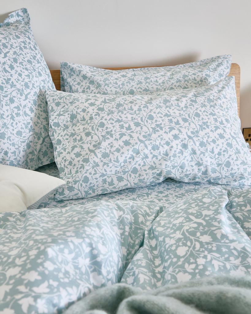 Add elegance to your bedding with the Foxford Claire Pillowcase Set in white. You feature a slate blue floral print on a lighter base, offering a subtle contrast for added visual interest.

Designed by renowned Irish designer Helen McAlinden, these pillowcases are crafted from 100% premium cotton. They have a luxurious 300-thread count for a soft, smooth finish. Expertly woven in Portugal, this set embodies the perfect balance of comfort and style.

The Foxford Claire Pillowcase Set pairs beautifully with o