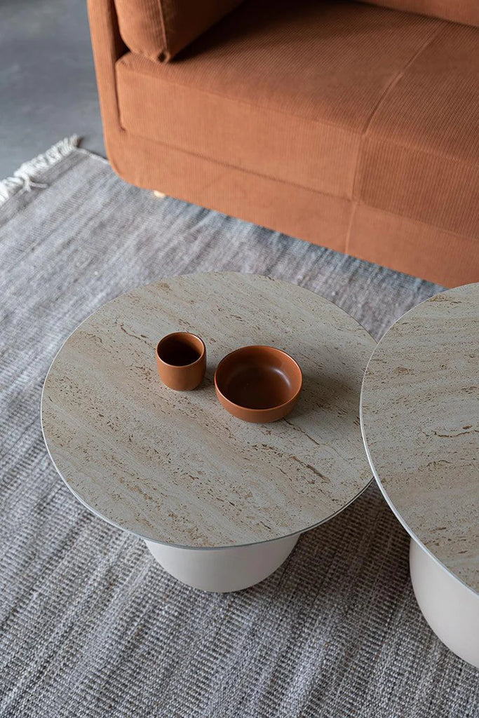 Foxford Casa Side Table - Short is a harmonious blend of natural design elements. Its ceramic tabletop boasts a beautiful travertine look, harmonizing effortlessly with the metal base. The soothing beige hue and organic round shape make this series a perfect addition to your living space.