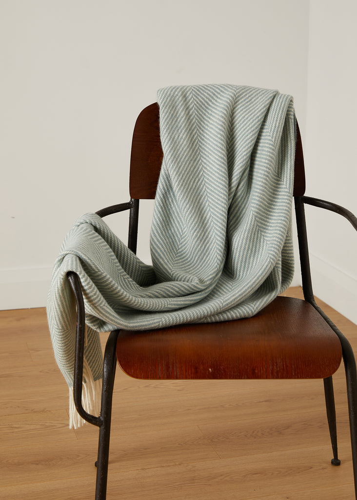 Transform your living space with the luxurious Foxford Aqua and White Merino Throw. Handcrafted from premium Merino wool at our County Mayo, Ireland mill, this stunning throw features a classic aqua and white giant herringbone pattern. Immerse yourself in the unmatched softness and warmth of Merino wool. Versatile and timeless, this throw will elevate the look and feel of any room.